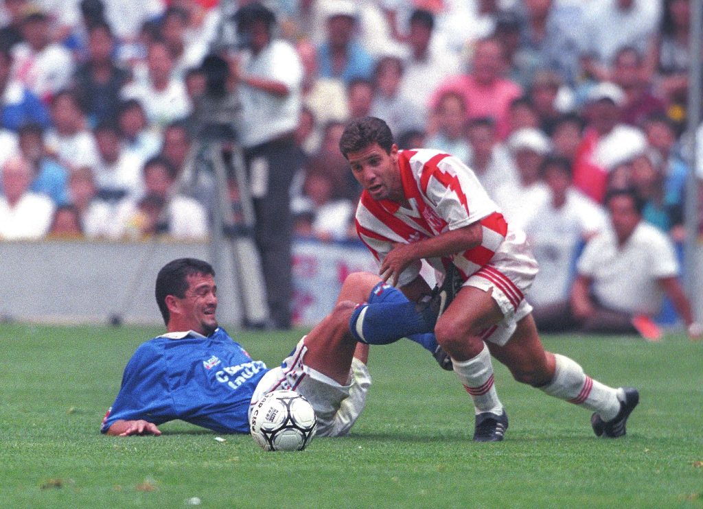 Foto de acción de Carlos Hermosillo disputando un balón con Cruz Azul